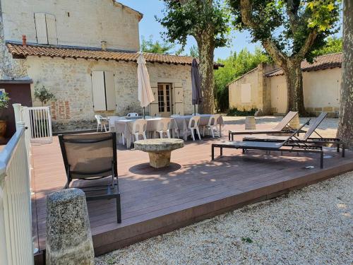 une terrasse en bois avec des chaises, une table et un parasol dans l'établissement Maison de charme avec Piscine Wi-Fi 10 personnes, à Comps