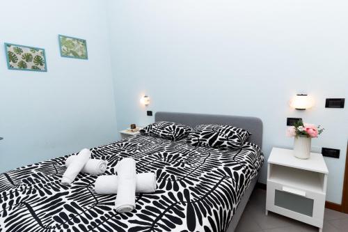 a bedroom with a black and white bed with pillows at Dolce Riviera Marina Centro in Rimini
