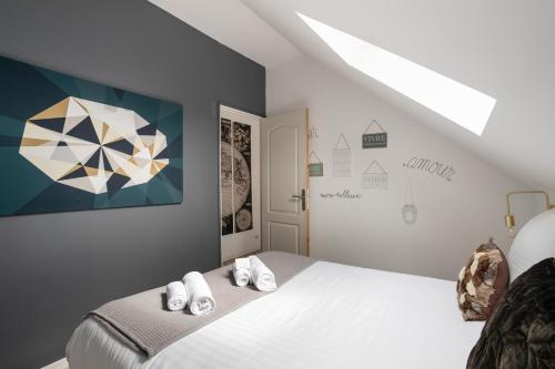 Un dormitorio con una cama con toallas. en Le Repos des Vagues - 4min de la Plage, en Dinard