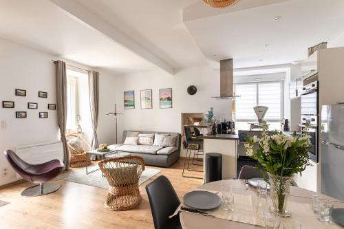 une cuisine et un salon avec une table et des chaises dans l'établissement Le Repos des Vagues - 4min de la Plage, à Dinard