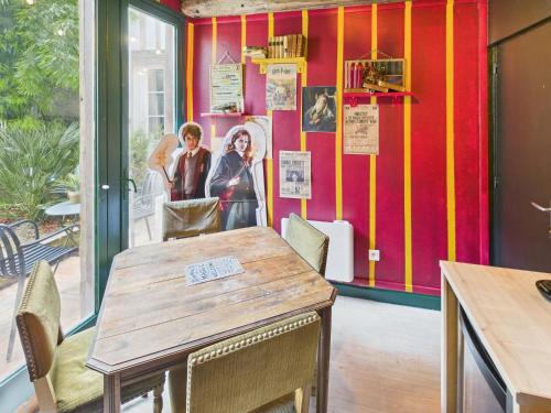 une salle à manger avec une table et un mur rouge dans l'établissement Harry-Potter, à Troyes