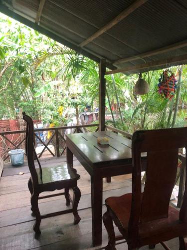 a wooden table and a chair on a porch at Sok Phen Homestay in Siem Reap