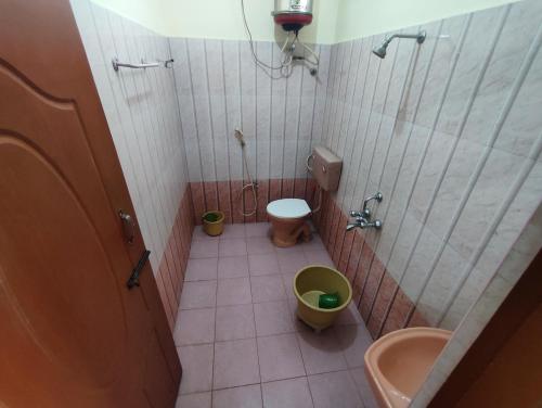 a small bathroom with a toilet and a sink at Golden Lake View Resorts in Yercaud