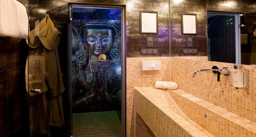 a bathroom with a shower with a painting of a woman at PLAZA INN stays design Dortmund in Dortmund