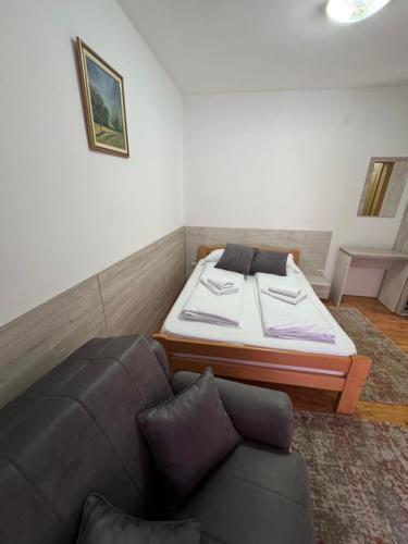 a room with a bed and a couch in it at Lisine Ribnjak in Despotovac
