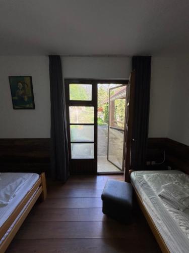 a bedroom with two beds and a sliding glass door at Lisine Ribnjak in Despotovac