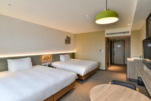 Rúm í herbergi á Holiday Inn Taoyuan Airport by IHG