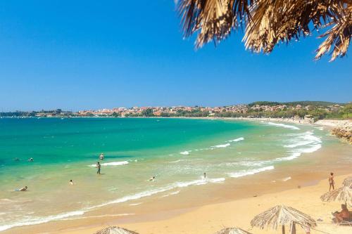 a group of people swimming in the ocean on a beach at Filiatra Cozy Cental Retreats with Balconies in Filiatra