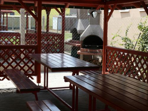 una mesa y bancos en una terraza con horno de pizza en Aquasleep, en Veľký Meder