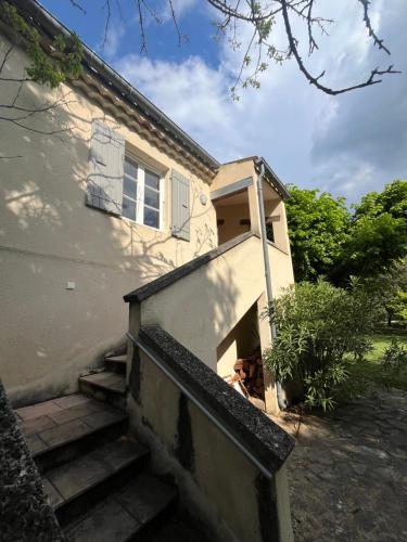 a house with stairs leading up to a building at La bergerie in Grignan