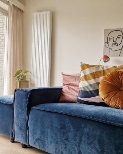a blue couch with pillows on it in a room at Fully equiped 100 m2 appt with the perfect location in Vilvoorde