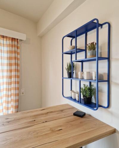 a blue shelf with potted plants on top of a wooden table at Fully equiped 100 m2 appt with the perfect location in Vilvoorde