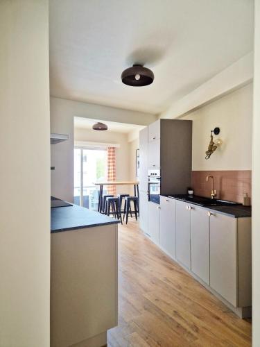 a kitchen with white cabinets and a dining room at Fully equiped 100 m2 appt with the perfect location in Vilvoorde