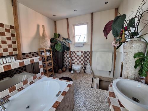 A B&B Amsterdam في أمستردام: حمام مع حوض استحمام كبير ومغسلة