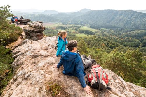 two people sitting on the edge of a mountain at Hotel Am Hirschhorn - Wellness - Spa - and more in Wilgartswiesen