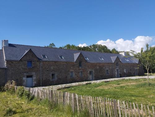 une ancienne maison en briques avec des panneaux solaires dans l'établissement Gîte de penhaudan 3, à Pont-Scorff