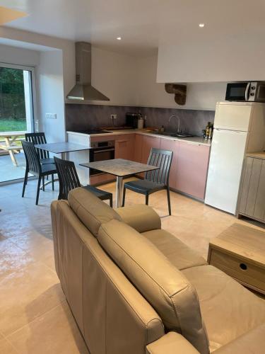un salon avec un canapé et des chaises et une cuisine dans l'établissement Gîte de penhaudan 3, à Pont-Scorff