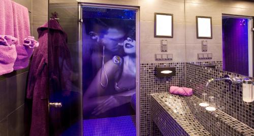 a bathroom with a picture of a woman in a shower at PLAZA INN stays design Dortmund in Dortmund