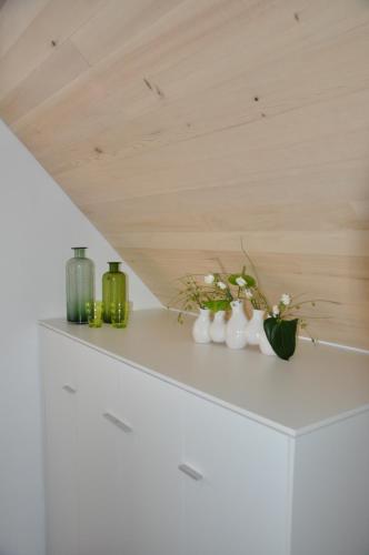 a shelf with vases and flowers on it at DIE KRONE - Hotel Garni in Kirchzarten