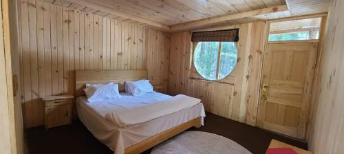 a bedroom with a bed in a wooden room at Kumrat Ecotourism Resort in Tāl