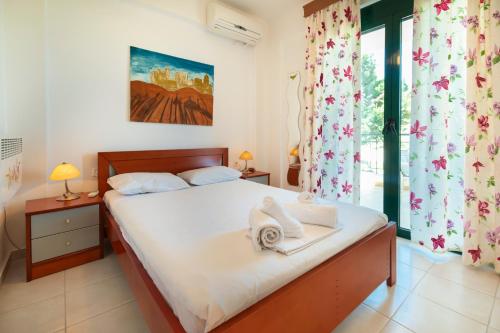 クリオピギにあるAriadni Sea View House by RentalsPro - Kryopigi Halkidikiのベッドとタオル2枚のある寝室