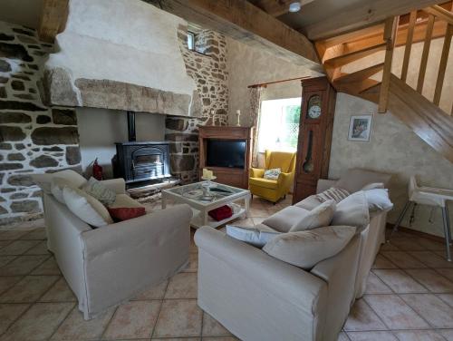 - un salon avec deux canapés et une cheminée en pierre dans l'établissement Maison historique avec jardin secret à Limerzel, à Limerzel