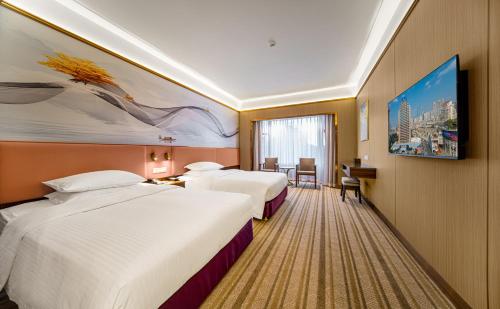 a hotel room with two beds and a painting on the wall at Millennium Harbourview Hotel Xiamen-Near Metro Station & Zhongshan Road in Xiamen
