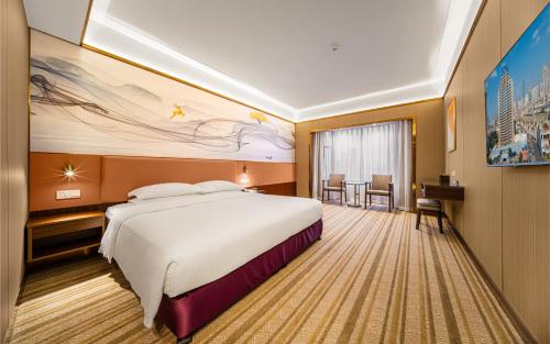 a hotel room with a large bed and a table at Millennium Harbourview Hotel Xiamen-Near Metro Station & Zhongshan Road in Xiamen