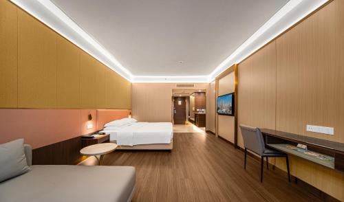 a hotel room with a bed and a desk at Millennium Harbourview Hotel Xiamen-Near Metro Station & Zhongshan Road in Xiamen