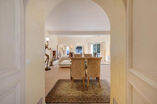 une arche mène à un salon avec une table et des chaises dans l'établissement L'EDEN - Grand Appartement avec extérieur de 300m2, piscine et vue mer, à Cannes