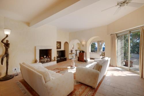 - un salon avec des chaises blanches et une cheminée dans l'établissement L'EDEN - Grand Appartement avec extérieur de 300m2, piscine et vue mer, à Cannes