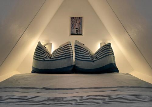 a bed with blue and white pillows in a room at Appartement Klein Waldeck in Velp
