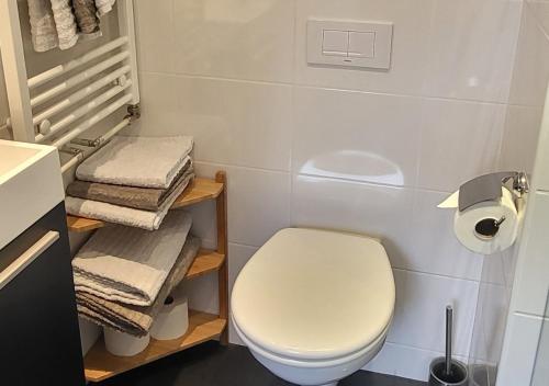 a bathroom with a white toilet and towels at Appartement Klein Waldeck in Velp