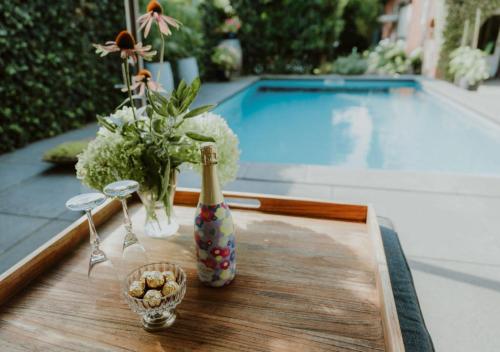 a table with a bottle of champagne and a vase of flowers at Appartement Klein Waldeck in Velp