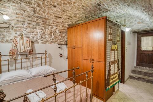 a bedroom with a bunk bed and a stone wall at Medieval Villa Philoxenia in Kalamoti