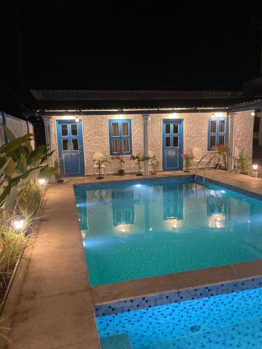 a swimming pool at night with lights at BoganVilla by Malpe in Cocoanut Island