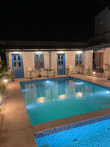 a swimming pool at night with lights on it at BoganVilla by Malpe in Cocoanut Island