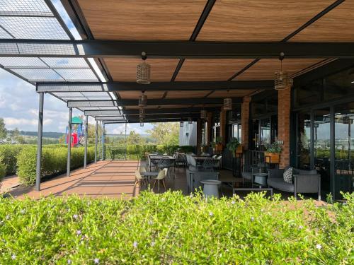 a patio with tables and chairs under a roof at Greenlee Lifestyle Apartment - One bedroom in Sandton