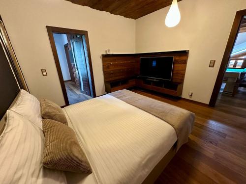a bedroom with a bed and a flat screen tv at Chalet Matthe Lomnica in Veľká Lomnica