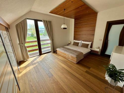 a bedroom with a bed and a large window at Chalet Matthe Lomnica in Veľká Lomnica