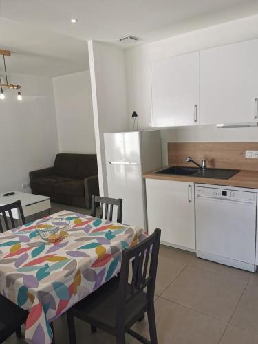 une cuisine et une table avec une nappe dessus dans une pièce dans l'établissement Maison Cosy au Cœur de St-Jean, à Saint-Jean-de-Védas