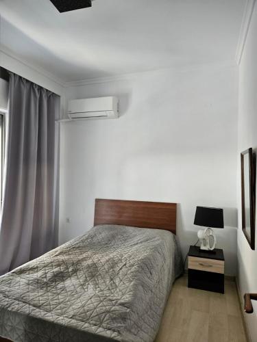a white bedroom with a bed and a window at Rapsani in Karianí