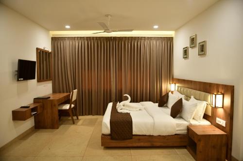 a bedroom with a large bed with a desk and a desk at Golden Star in Kollam