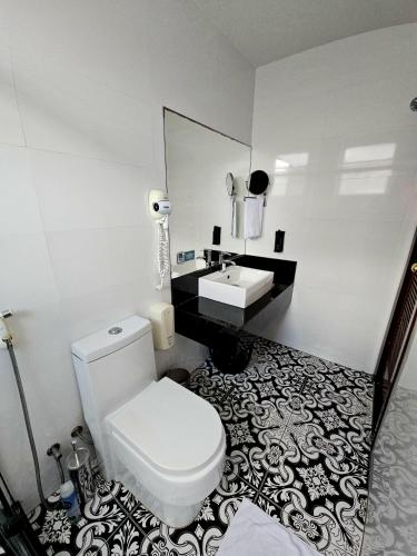 a bathroom with a white toilet and a sink at Hospedaria Santiago in Teresópolis