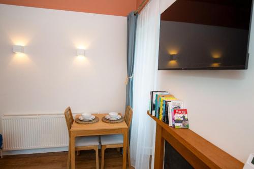 a small table with two chairs and a television on a wall at West Lodge, High Street in Aberlour