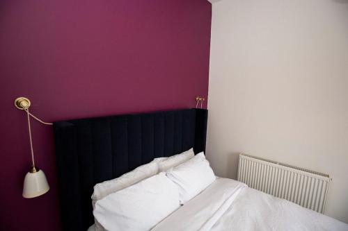 a bed with a black headboard and white pillows at West Lodge, High Street in Aberlour