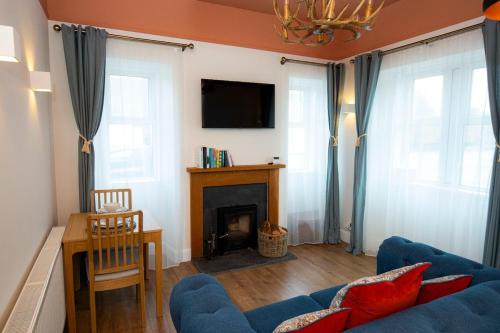 a living room with a blue couch and a fireplace at West Lodge, High Street in Aberlour