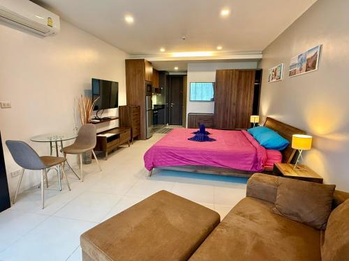 a large bedroom with a bed and a couch at Escape Condominiums Beachfront Suites - Mae Phim in Rayong