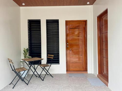 a room with two chairs and a table and a wooden door at The 19th Transient House in Solano 1 in Solano