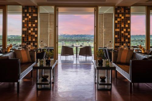 a restaurant with couches and tables with a view at Victoria Golf Resort and Spa Managed by Accor in Vilamoura